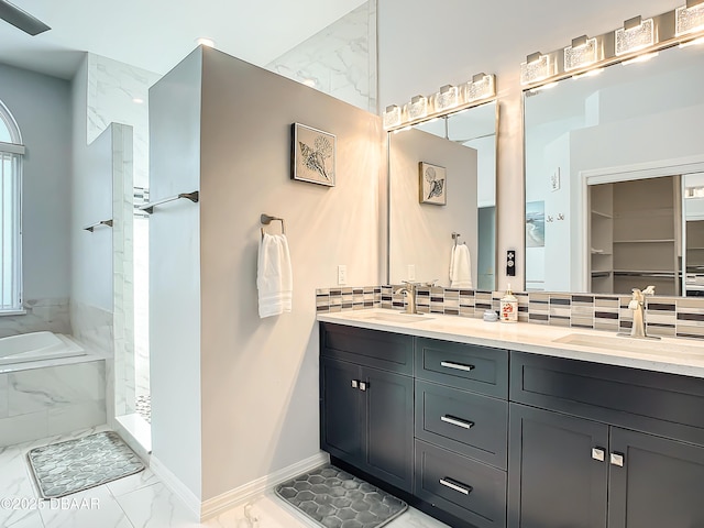 bathroom featuring backsplash, shower with separate bathtub, and vanity