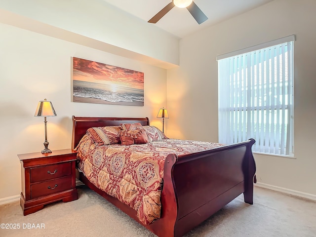 bedroom with light carpet, multiple windows, and ceiling fan