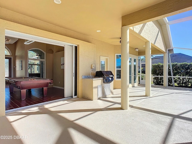 view of patio featuring a mountain view, an outdoor kitchen, and a grill