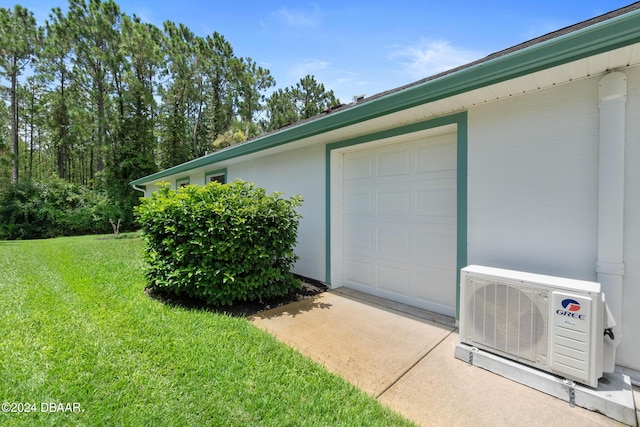 garage with ac unit and a yard