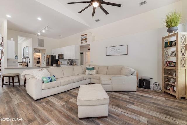 living room featuring track lighting, wood-type flooring, sink, and ceiling fan