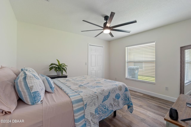 bedroom with a textured ceiling, a closet, ceiling fan, and light hardwood / wood-style floors