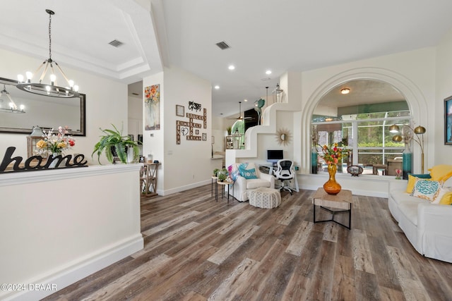 living room featuring a tray ceiling, a chandelier, and hardwood / wood-style floors