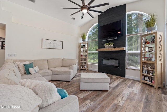 living room with lofted ceiling, a fireplace, hardwood / wood-style floors, and ceiling fan