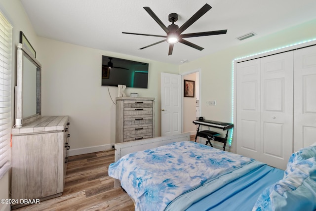 bedroom featuring ceiling fan, light hardwood / wood-style floors, and a closet