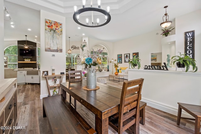 dining space with sink, an inviting chandelier, and hardwood / wood-style flooring