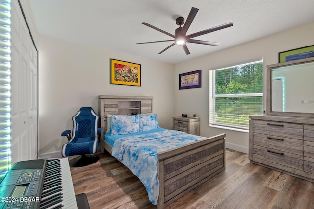 bedroom with a textured ceiling, wood-type flooring, ceiling fan, and a closet