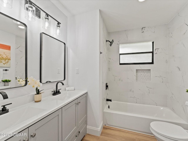 bathroom with shower / bath combination, a sink, wood finished floors, and double vanity