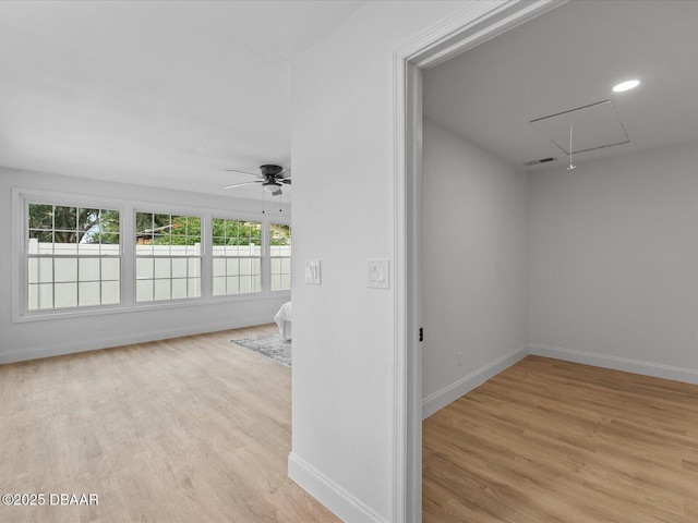 interior space with visible vents, attic access, light wood-style flooring, and ceiling fan