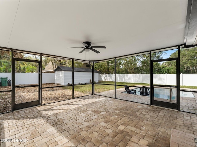 unfurnished sunroom featuring ceiling fan