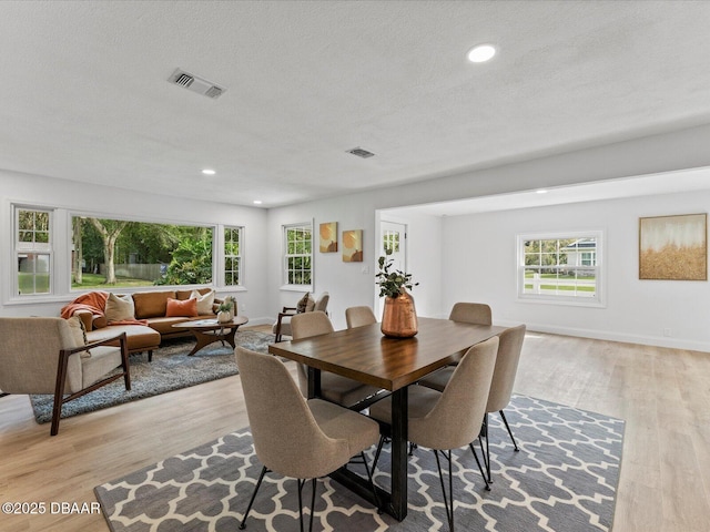 dining room featuring baseboards, recessed lighting, wood finished floors, and visible vents