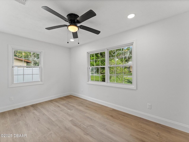 empty room featuring baseboards, recessed lighting, and light wood finished floors