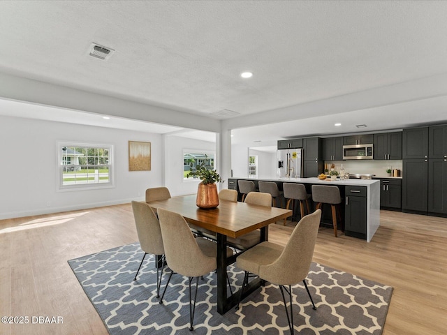 dining area featuring recessed lighting, visible vents, and light wood-style flooring
