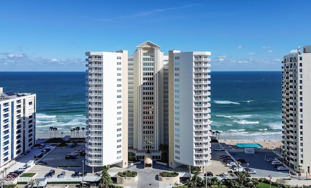 view of building exterior featuring a beach view and a water view