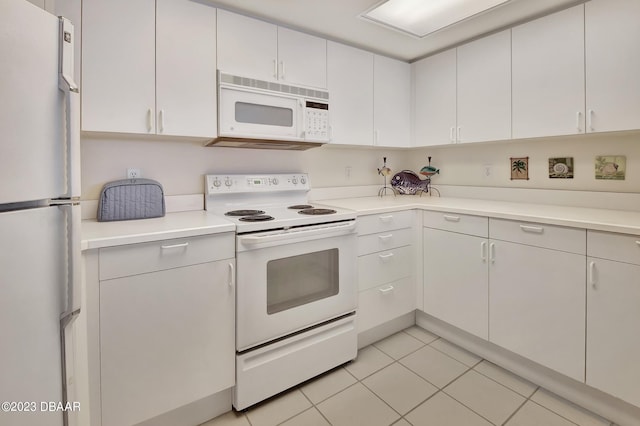 kitchen with white cabinets, light tile patterned floors, and white appliances