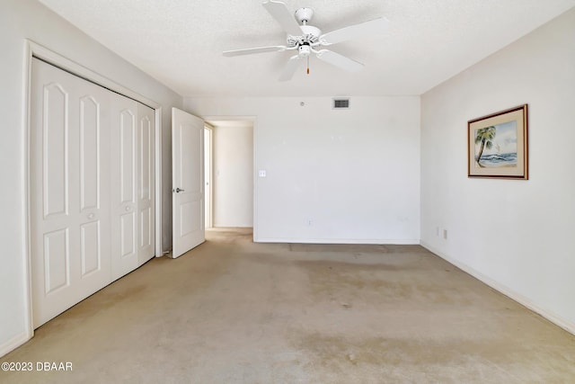 unfurnished bedroom featuring a textured ceiling, light carpet, ceiling fan, and a closet