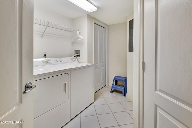 washroom featuring separate washer and dryer, electric panel, and light tile patterned flooring