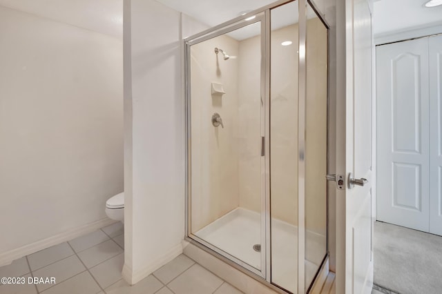 bathroom featuring tile patterned floors, toilet, and an enclosed shower