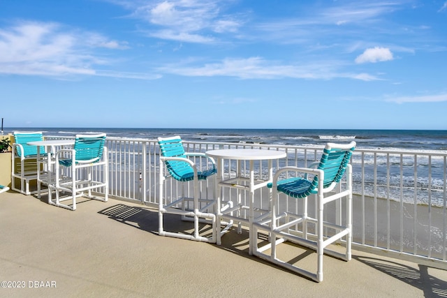 balcony featuring a water view and a beach view