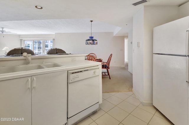 kitchen featuring sink, ceiling fan, white appliances, light colored carpet, and pendant lighting