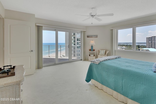 2937 S Atlantic Ave Unit 1108, Daytona Beach Shores, FL 32118 - carpeted bedroom featuring access to exterior, multiple windows, a water view, and a ceiling fan