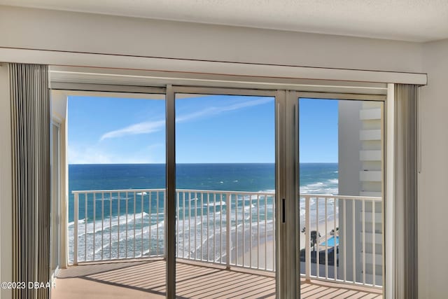 interior space featuring a wealth of natural light, a beach view, and a water view