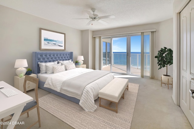 carpeted bedroom with ceiling fan, a textured ceiling, access to exterior, and a water view