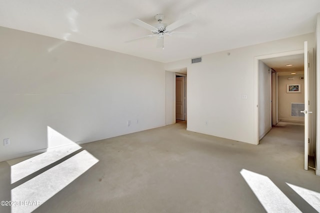 spare room featuring light colored carpet and ceiling fan