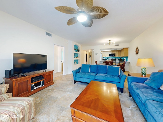 living room with built in shelves and ceiling fan