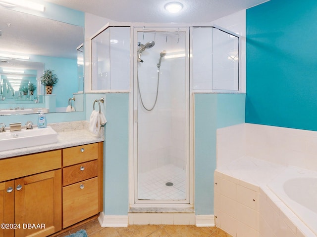 bathroom featuring tile patterned flooring, vanity, a textured ceiling, and plus walk in shower