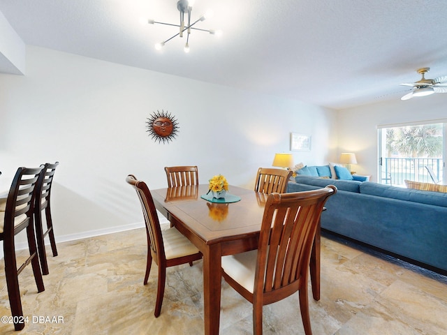 dining area featuring ceiling fan with notable chandelier