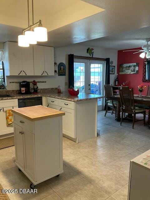 kitchen featuring dishwasher, french doors, hanging light fixtures, a kitchen island, and white cabinets