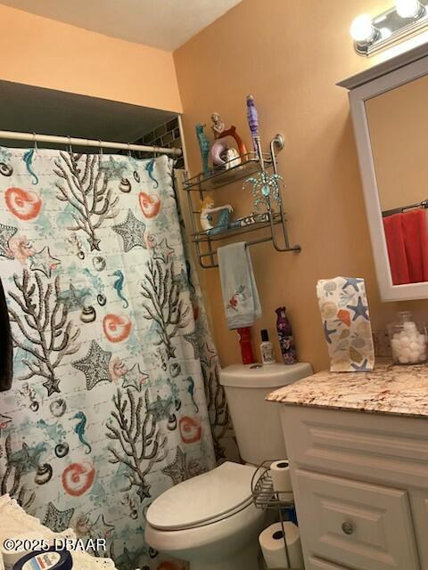 bathroom with toilet, a shower with shower curtain, and vanity