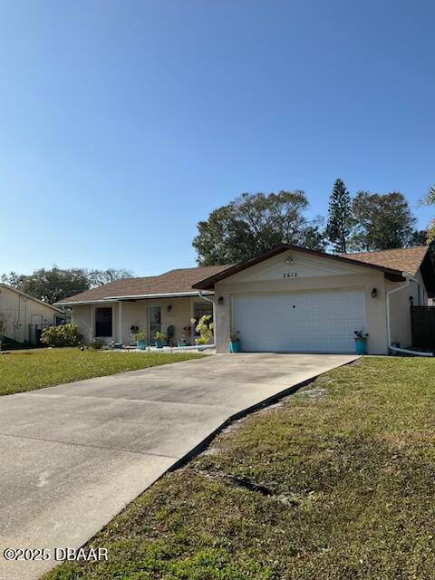 ranch-style house with a garage and a front lawn