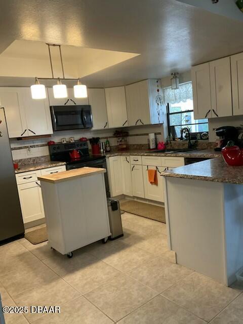 kitchen with white cabinetry, hanging light fixtures, stainless steel refrigerator, a kitchen island, and sink