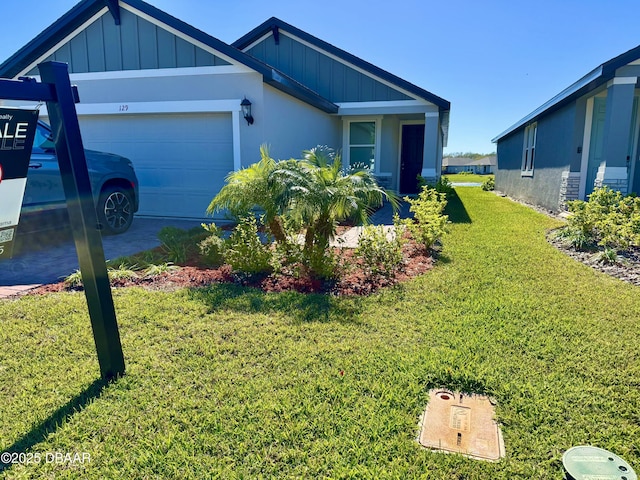 view of front of home with an attached garage, board and batten siding, and a front yard