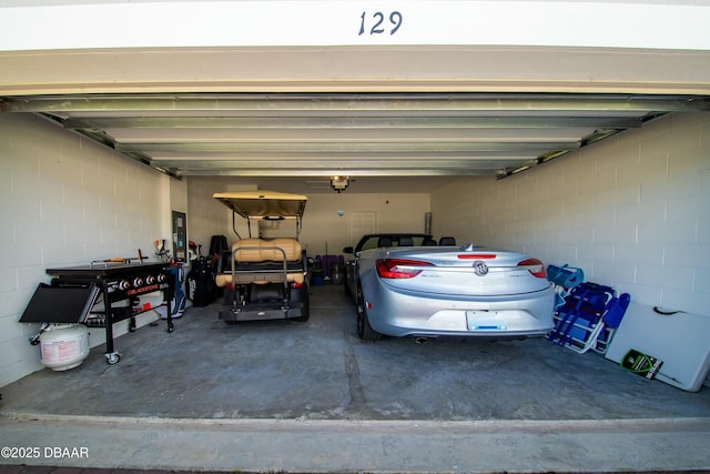 garage featuring concrete block wall and a garage door opener