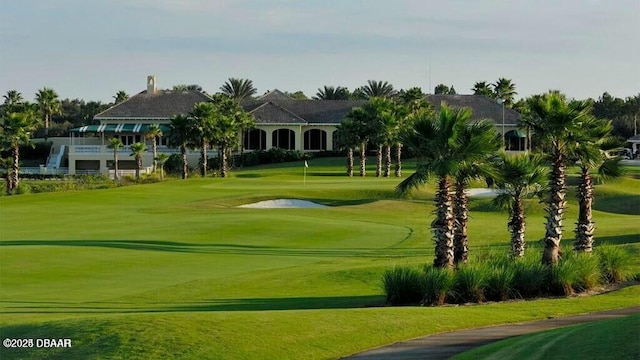 view of community with a yard and golf course view