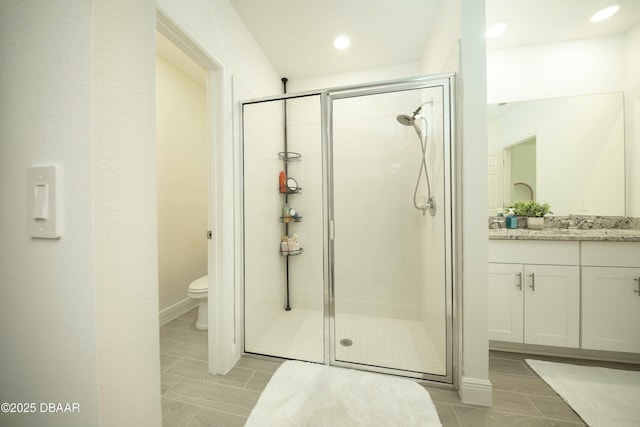 full bathroom with vanity, a shower stall, toilet, and recessed lighting