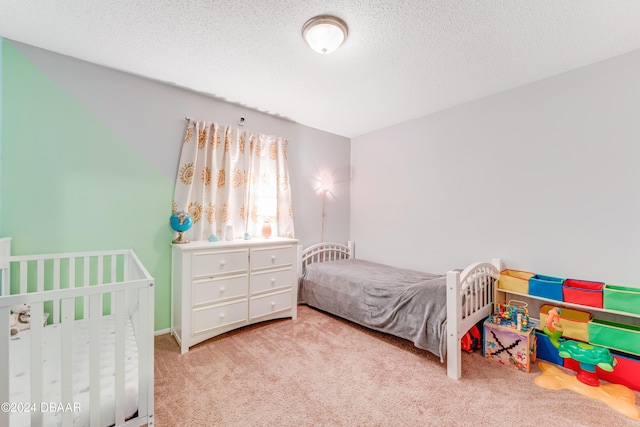 bedroom featuring light carpet and a textured ceiling