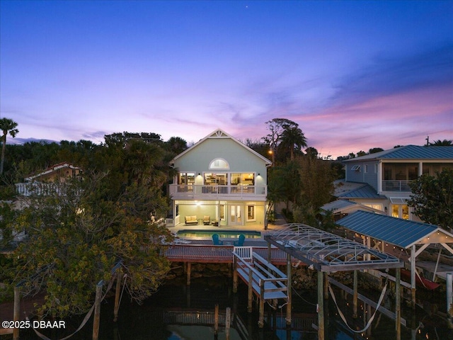 3110 John Anderson Dr, Ormond Beach, FL 32176 - back house at dusk with a patio area and a balcony