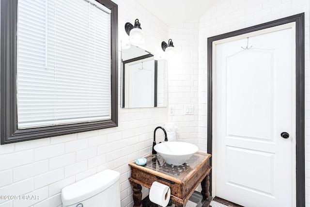 3110 John Anderson Dr, Ormond Beach, FL 32176 - bathroom with toilet, sink, and tile walls