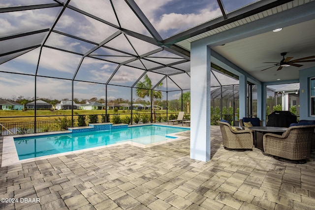 view of swimming pool featuring ceiling fan, a patio, and a lanai