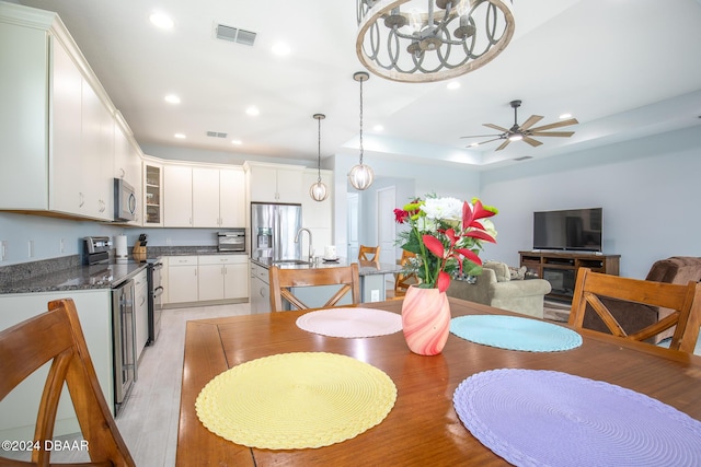 dining space featuring ceiling fan, sink, and light hardwood / wood-style floors