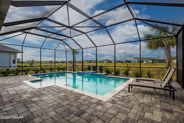 view of swimming pool with glass enclosure, a patio area, and pool water feature