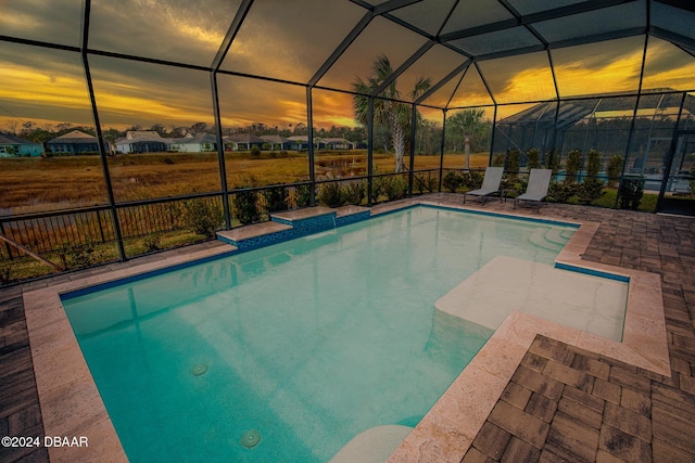 pool at dusk with a lanai