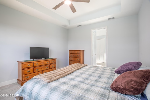 bedroom featuring ceiling fan and a tray ceiling