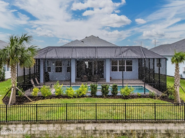 rear view of house featuring a lanai, a fenced in pool, and a yard