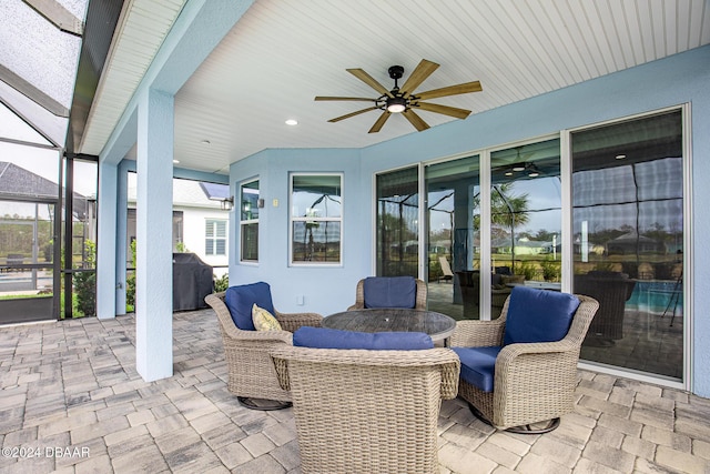 view of patio / terrace featuring a lanai, ceiling fan, and area for grilling