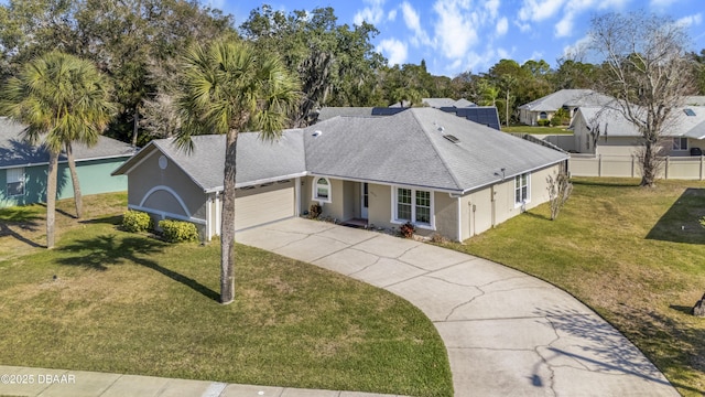 view of front facade featuring an attached garage, driveway, a front lawn, and a shingled roof